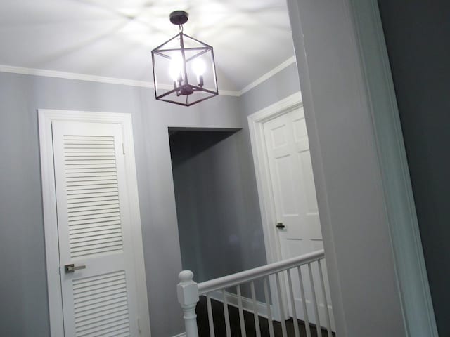 stairs with a chandelier, crown molding, and baseboards