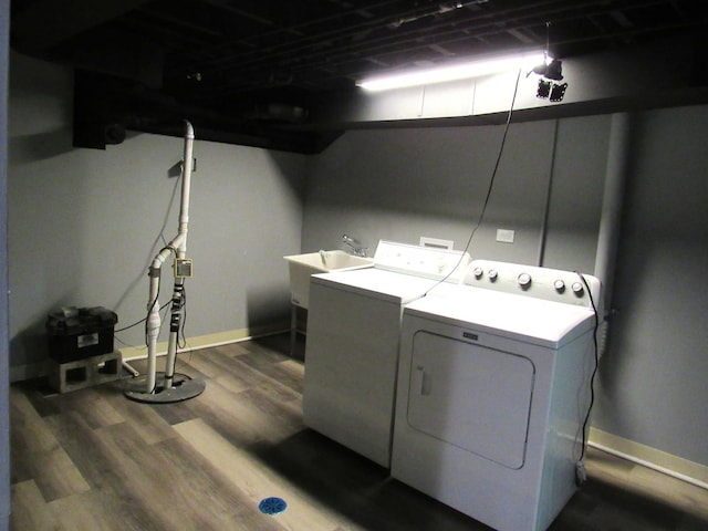 clothes washing area featuring washer and clothes dryer, dark wood-style flooring, and baseboards