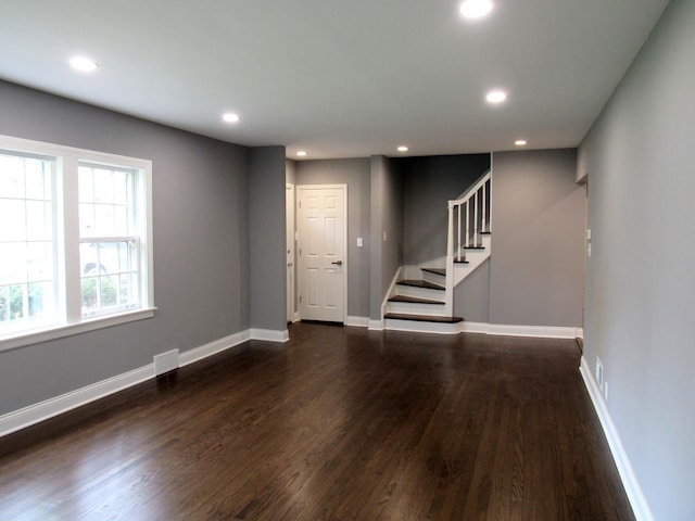 unfurnished living room featuring dark wood-style floors, stairway, recessed lighting, and baseboards