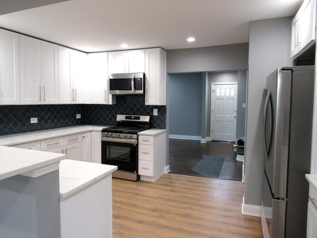 kitchen with stainless steel appliances, decorative backsplash, white cabinets, and recessed lighting