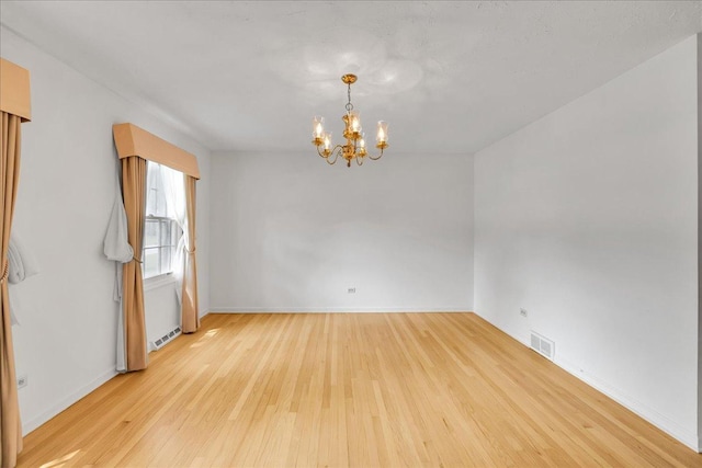 26W266 Tomahawk Dr, Wheaton, IL 60189 - unfurnished room with a chandelier, hardwood / wood-style floors, and baseboards