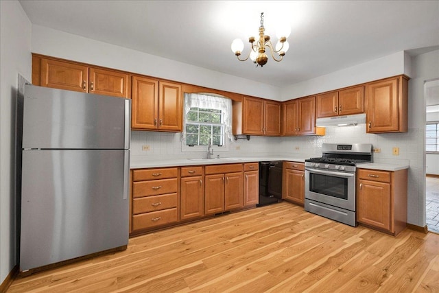 26W266 Tomahawk Dr, Wheaton, IL 60189 - kitchen with appliances with stainless steel finishes, under cabinet range hood, a sink, brown cabinetry, and light countertops