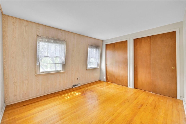 26W266 Tomahawk Dr, Wheaton, IL 60189 - unfurnished bedroom with multiple closets and wood finished floors