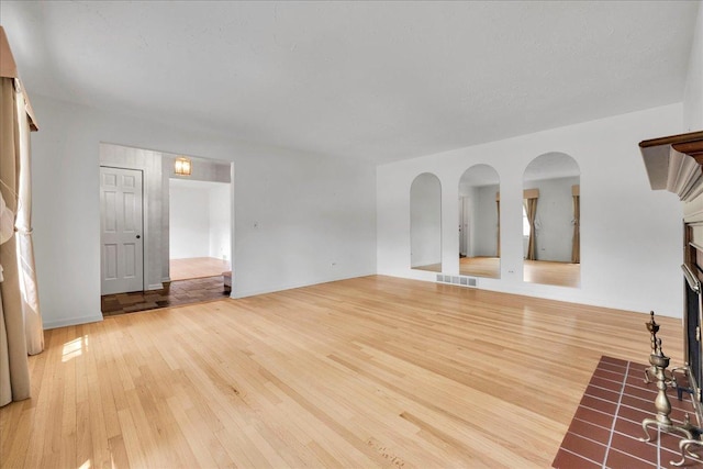 26W266 Tomahawk Dr, Wheaton, IL 60189 - unfurnished living room with light wood-style flooring and a fireplace with flush hearth