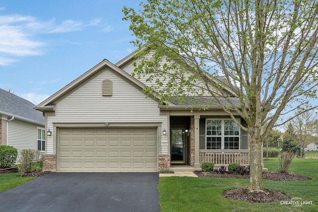 traditional home with a porch, brick siding, a garage, and aphalt driveway