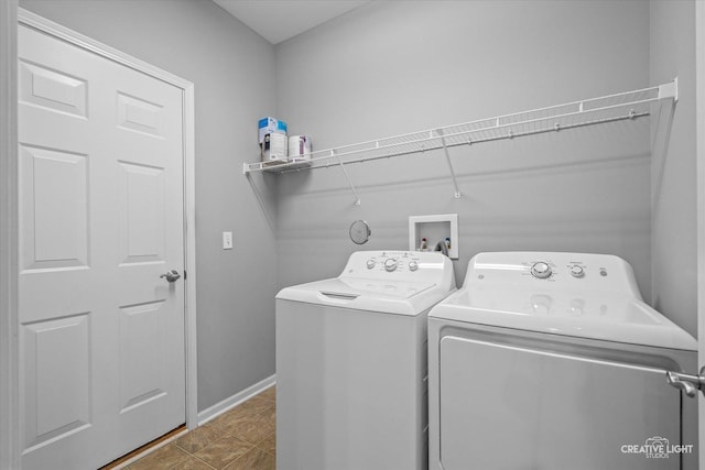 clothes washing area featuring laundry area, baseboards, and washer and dryer