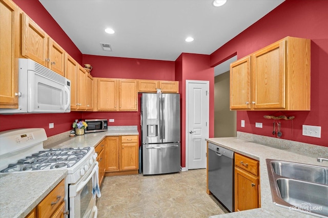 kitchen featuring a sink, appliances with stainless steel finishes, light countertops, and visible vents