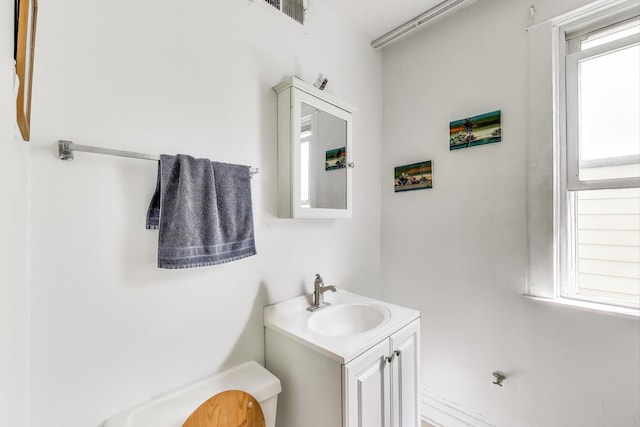 half bath featuring toilet, visible vents, and vanity