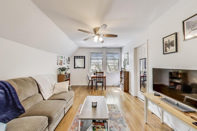 living area featuring baseboards, light wood-style floors, ceiling fan, and lofted ceiling