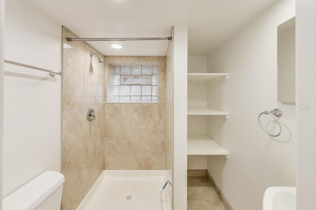 bathroom featuring a stall shower, baseboards, and toilet
