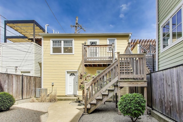 back of house with stairway, a wooden deck, a fenced backyard, and central AC
