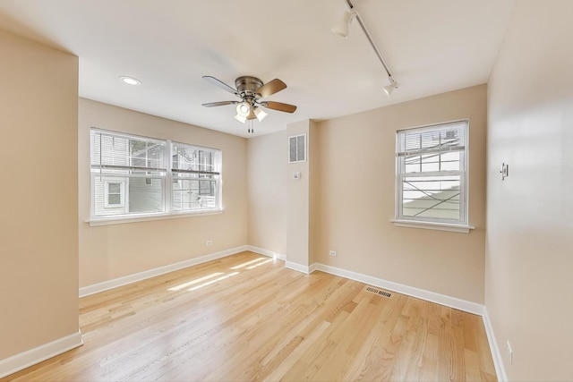 spare room with baseboards, a ceiling fan, and visible vents
