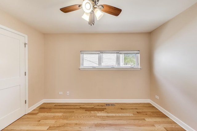 spare room featuring light wood-style flooring, baseboards, a ceiling fan, and visible vents