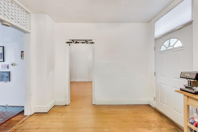 entryway featuring light wood-style floors and baseboards