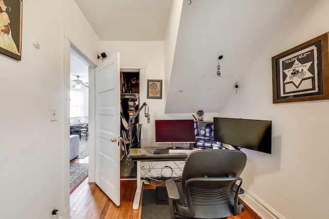 home office featuring baseboards, a ceiling fan, and hardwood / wood-style flooring