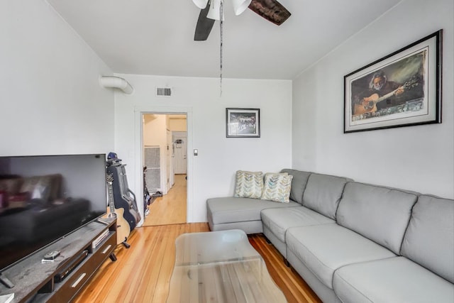 living room with light wood-style floors, visible vents, and ceiling fan