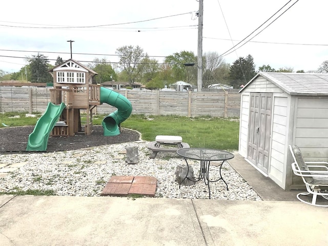 view of patio featuring a playground, an outdoor structure, a fenced backyard, and a shed