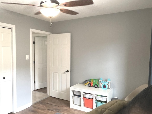 rec room with ceiling fan and wood finished floors