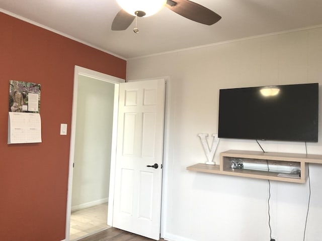 unfurnished bedroom featuring ceiling fan, baseboards, ornamental molding, and wood finished floors