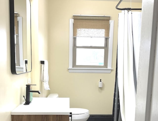 full bathroom with vanity, baseboards, toilet, and curtained shower