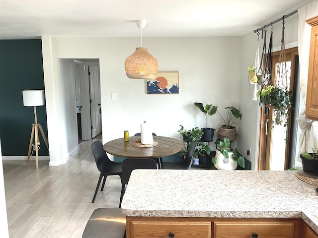 dining room featuring baseboards and light wood-type flooring