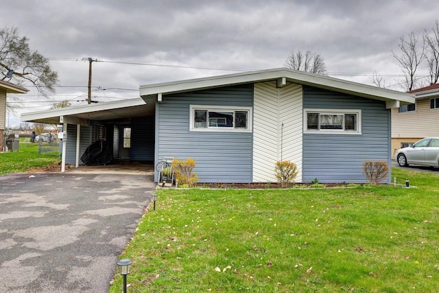 66W Jeffery Ave, Wheeling, IL 60090 - view of front facade featuring an attached carport, aphalt driveway, and a front yard