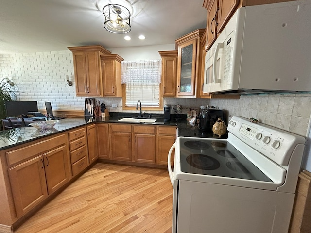 kitchen with white appliances, a sink, brown cabinetry, and recessed lighting