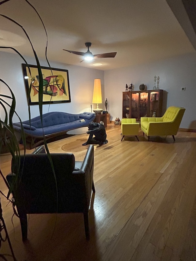 living area featuring wood finished floors and a ceiling fan