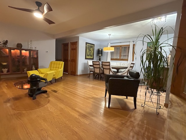 living area with wood finished floors and ceiling fan