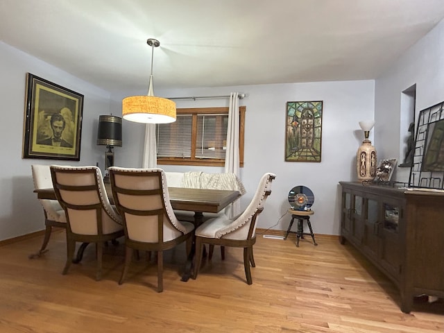 dining room with light wood-style floors and baseboards