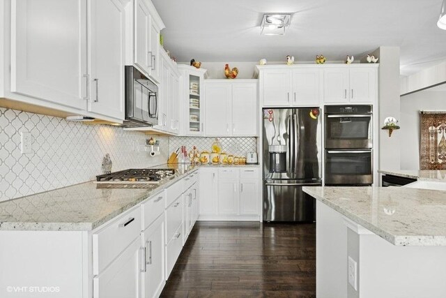 1683 Rockefeller Dr, Mundelein, IL 60060 - kitchen with appliances with stainless steel finishes, white cabinetry, dark wood-type flooring, glass insert cabinets, and light stone countertops