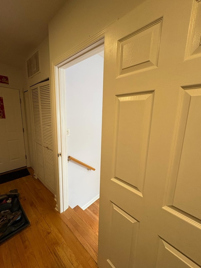hall with wood finished floors and visible vents