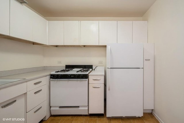 kitchen featuring light countertops, white cabinetry, and white appliances