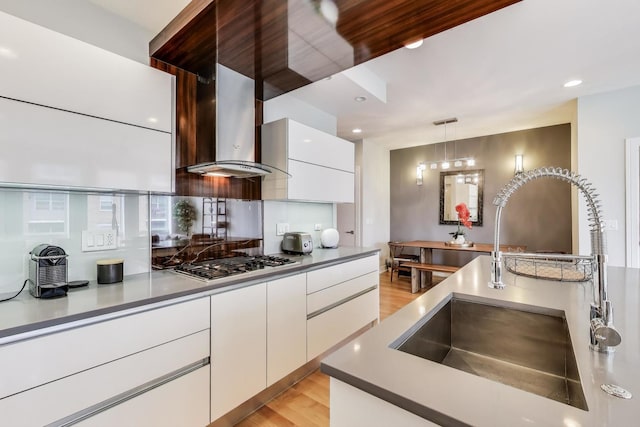 kitchen with a sink, white cabinetry, stainless steel gas cooktop, and modern cabinets