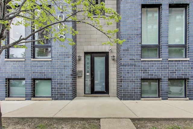 doorway to property featuring brick siding