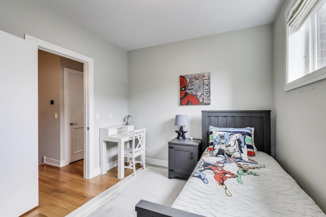 bedroom featuring baseboards, visible vents, and light wood-style floors