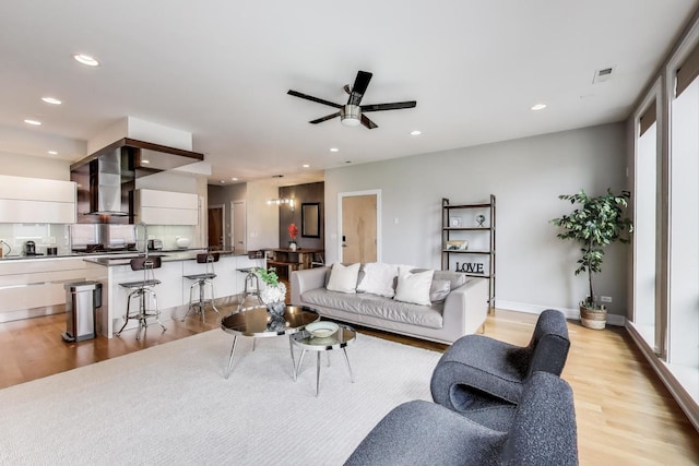 living area with recessed lighting, light wood finished floors, and ceiling fan