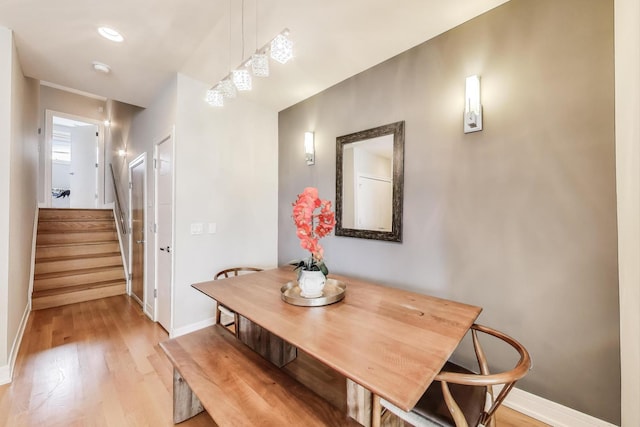 dining room with stairway, baseboards, and light wood-style floors