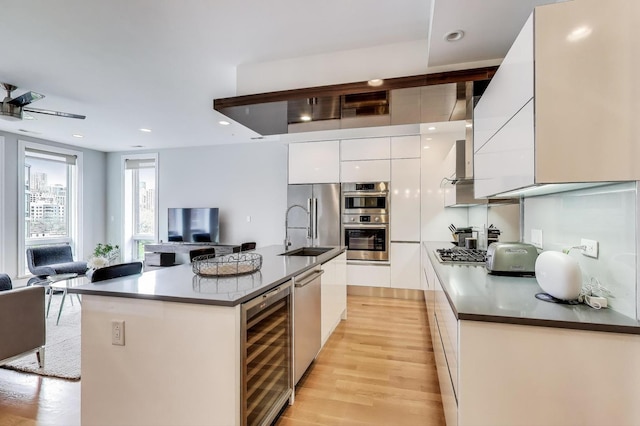 kitchen featuring white cabinetry, open floor plan, beverage cooler, modern cabinets, and appliances with stainless steel finishes