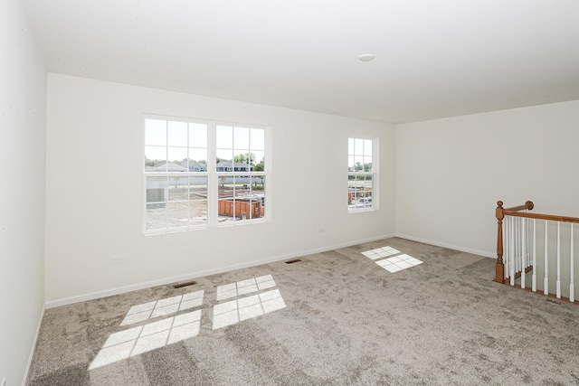 carpeted empty room with visible vents and baseboards