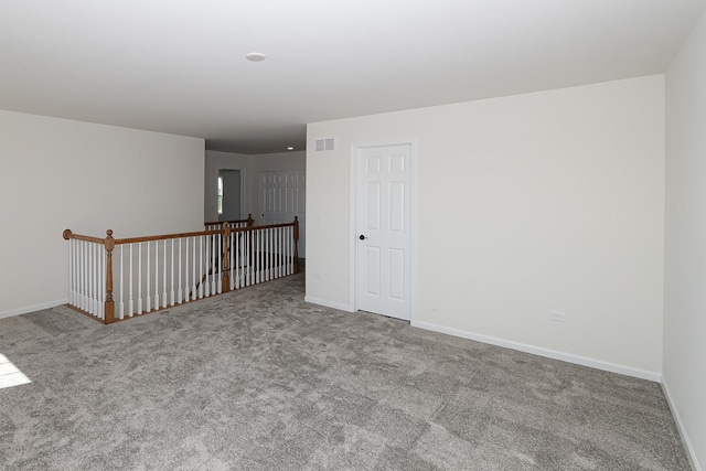 carpeted empty room featuring visible vents and baseboards