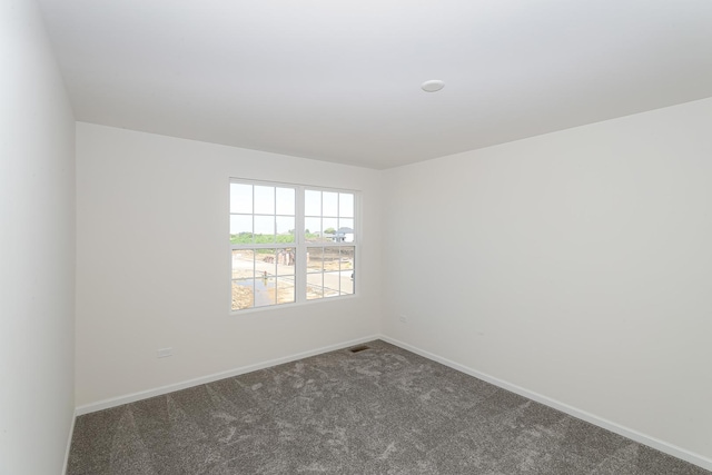 carpeted empty room featuring baseboards and visible vents