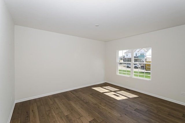 empty room featuring baseboards and wood-type flooring