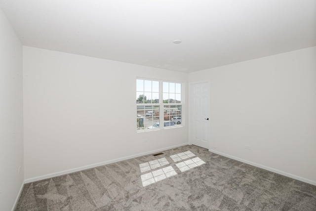 unfurnished room with baseboards, carpet, and visible vents