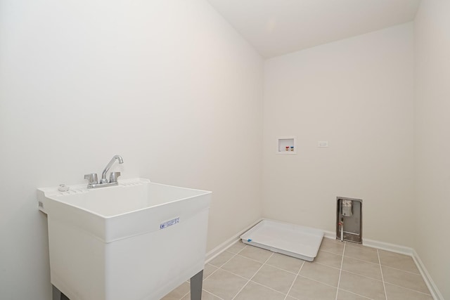 laundry room with laundry area, washer hookup, a sink, baseboards, and light tile patterned floors