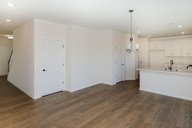 kitchen with light countertops, recessed lighting, dark wood finished floors, and a sink