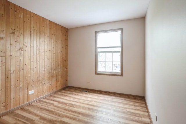 1326 Narragansett Dr, Carol Stream, IL 60188 - spare room with wood walls, light wood-type flooring, and baseboards