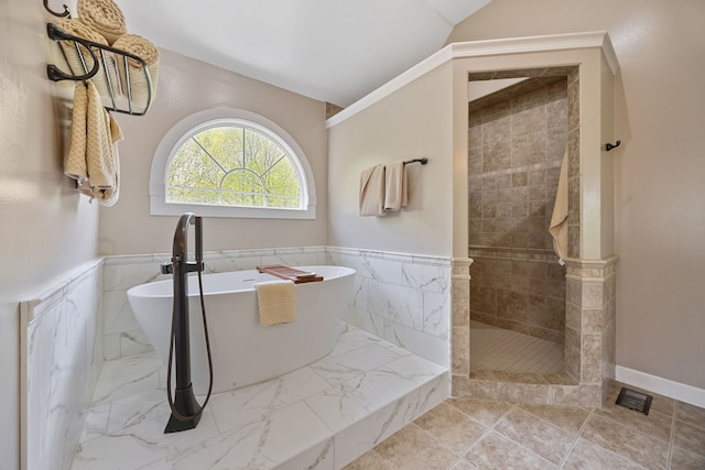 610 Wind Energy Pass, Batavia, IL 60510 - bathroom featuring a soaking tub, walk in shower, a wainscoted wall, marble look tiles, and vaulted ceiling