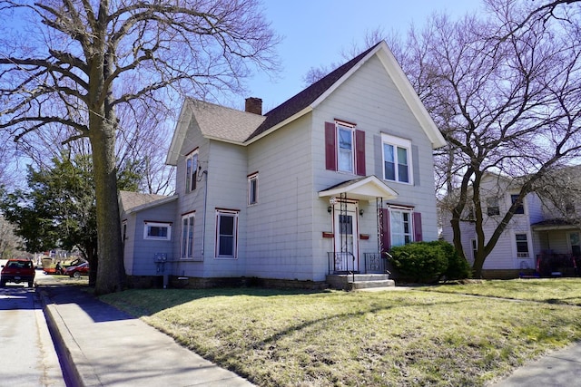 221 N Main St, Wilmington, IL 60481 - view of front of house featuring roof with shingles, a chimney, and a front yard