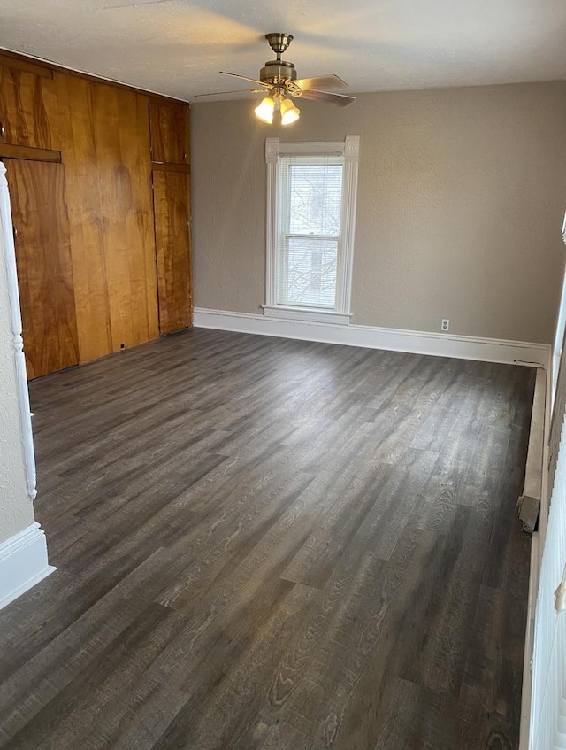 221 N Main St, Wilmington, IL 60481 - empty room with baseboards, ceiling fan, and dark wood-style floors